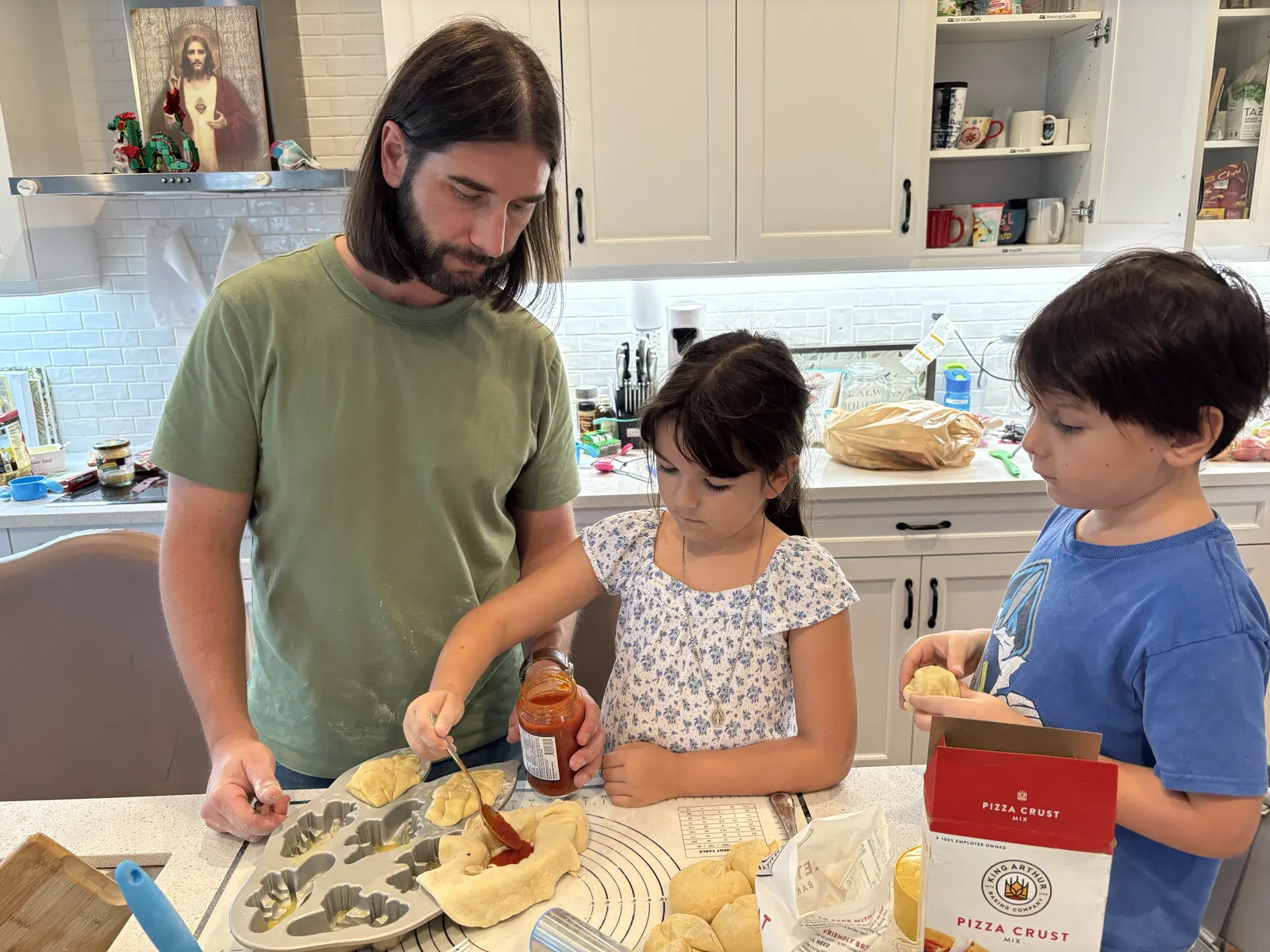 Patrick Dobbins making pizza with two of the children